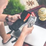 person holding wallet and US dollar bills