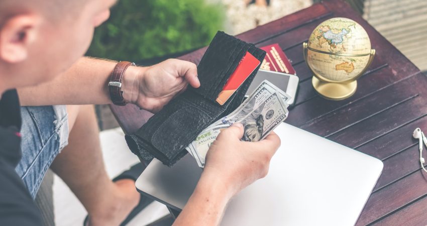 person holding wallet and US dollar bills