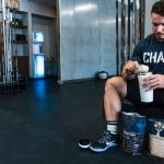 man in black crew neck t-shirt holding white plastic cup